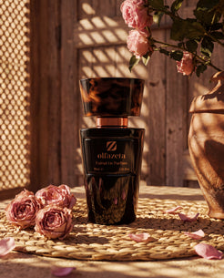 Flacon noir Olfazeta by Chogan Millésime N°105 sur set en osier, roses roses et jarre en terre cuite